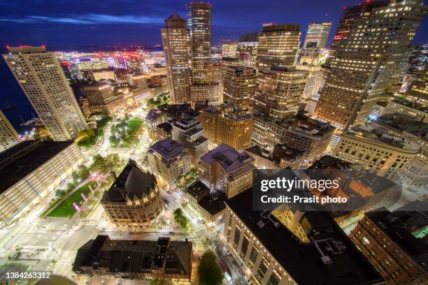 aerial view of boston harbor and financial district at night in boston, massachusetts, usa. - boston harbor stock-fotos und bilder