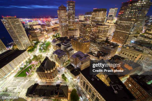 aerial view of boston harbor and financial district at night in boston, massachusetts, usa. - boston massachusetts foto e immagini stock