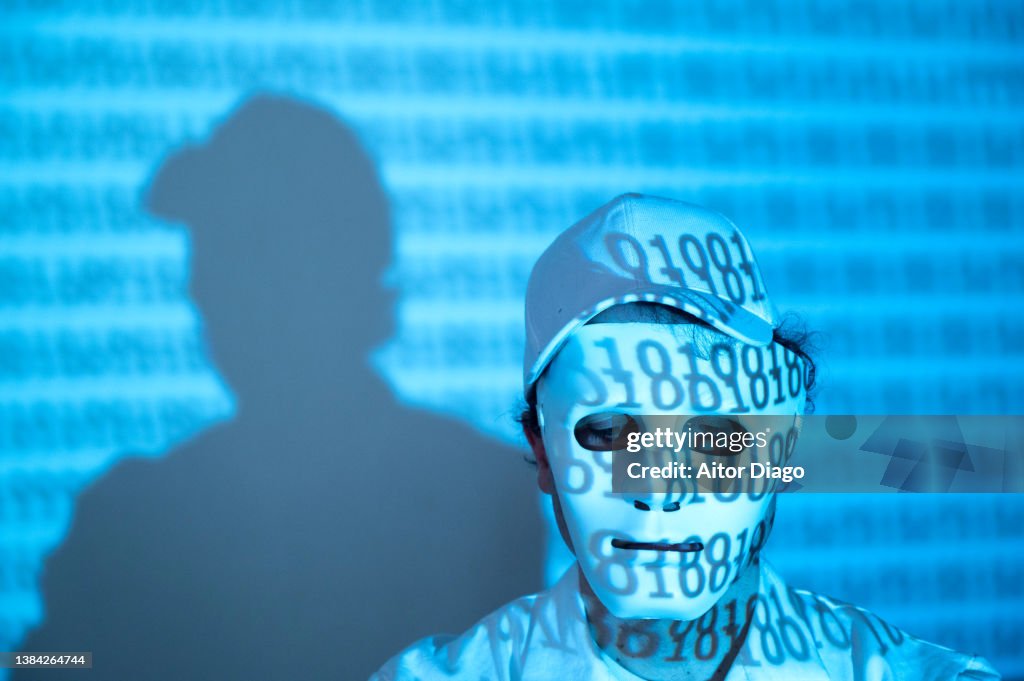 Portrait of an unrecognisable person with a mask covered binary code on his clothes.