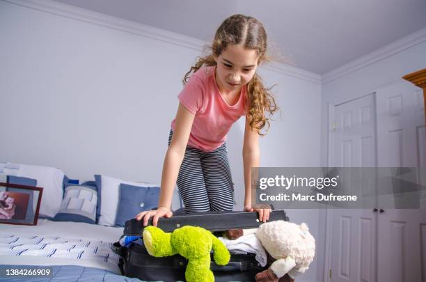 teenager-mädchen, das versucht, einen zu vollen koffer zu schließen - suitcase close stock-fotos und bilder