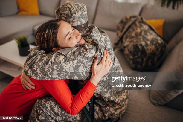 military soldier with crutches coming  home to his wife from the war - army wife stock pictures, royalty-free photos & images