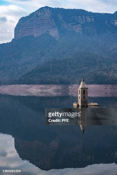 cereal footage of half drown bell tower in lake - sunken stockfoto's en -beelden
