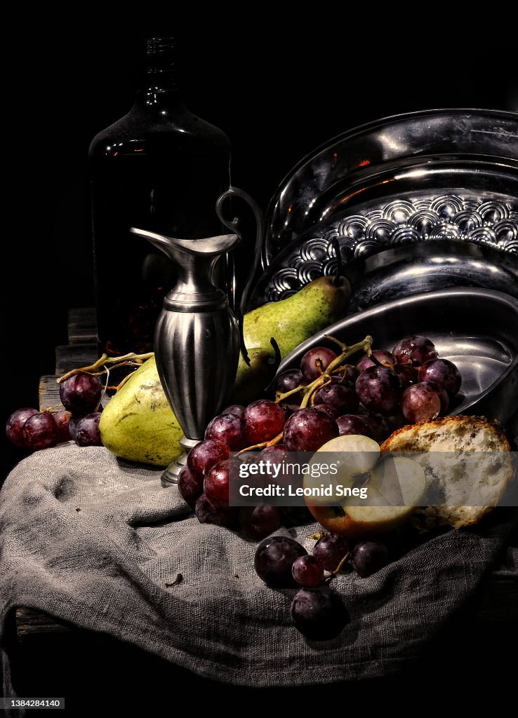 Artistic still life with fruits and metal dishes side view on black background closeup. Selective focus
