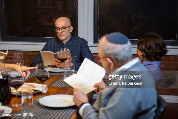 seder leader reading from the haggadah - seder 個照片及圖片檔