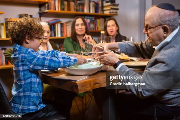 multigenerational family washing hands at passover seder - passover stockfoto's en -beelden