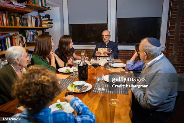 seder leader holding up matzo - passover stockfoto's en -beelden