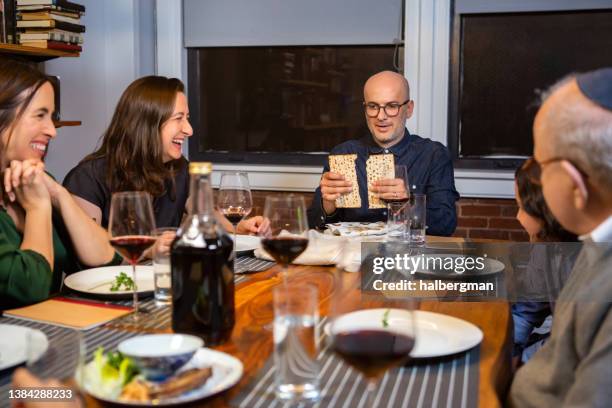 breaking matzo at family passover seder - judaism stock pictures, royalty-free photos & images