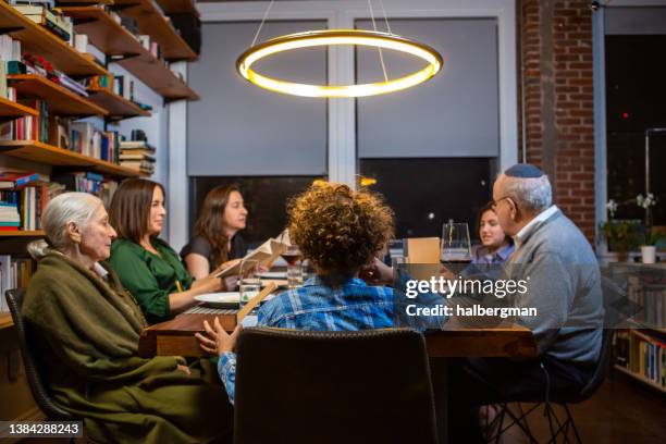 multi-generational family passover seder - jewish people stock pictures, royalty-free photos & images