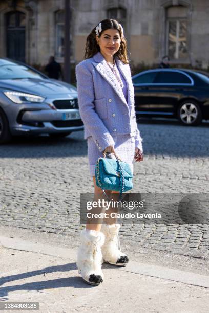 Guest wearing a lilac tweed blazer with matching skirt, blue Chanel and cream fur Chanel boots, is seen outside Chanel, during Paris Fashion Week -...