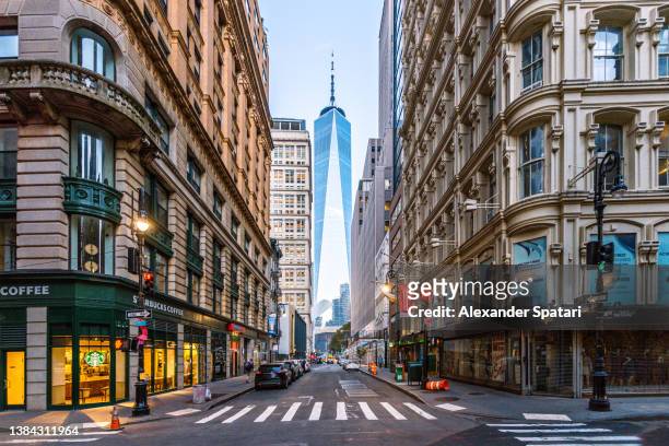 street in manhattan downtown with one world trade center in the middle, new york city, usa - big apple stock pictures, royalty-free photos & images