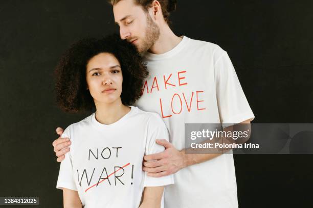 peaceful couple with slogans make love not war. - slogan t shirt fotografías e imágenes de stock