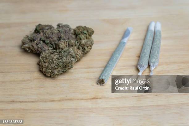 mairjuana buds with cannabis rolled joints on wooden background.medical cannabis and medicine concept. - cannabis droge stockfoto's en -beelden