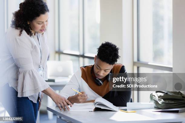 librarian helps college student - docent stockfoto's en -beelden