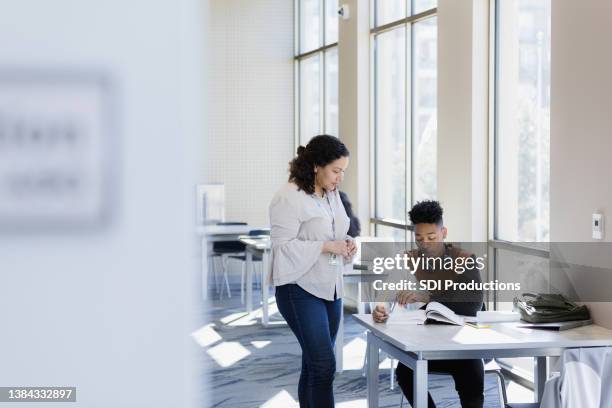 professor talks with student - laatstejaars high school stockfoto's en -beelden