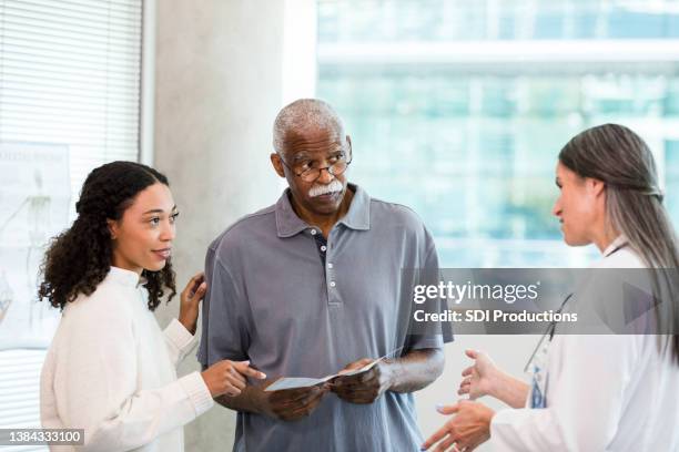 granddaughter has questions when doctor discusses home healthcare for grandfather - family decisions stock pictures, royalty-free photos & images