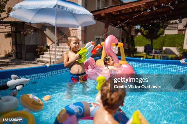 happy children having fun playing games in swimming pool - kids pool games stock pictures, royalty-free photos & images