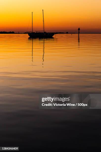 silhouette of sailboats in sea against sky during sunset,dauphin island,alabama,united states,usa - mobile alabama fotografías e imágenes de stock