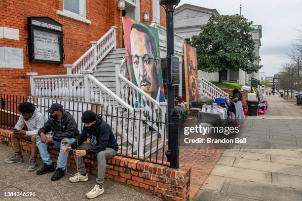 People sit near the Dexter Avenue King Memorial Baptist Church during a rally at the Alabama State Capitol on March 11, 2022 in Montgomery, Alabama....