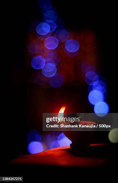 diwali vibes,close-up of illuminated diya against black background - diya oil lamp stock-fotos und bilder