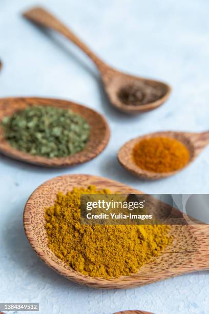 flat lay arrangement of dried ground spices and herbs in spoons - smelling spices at food market stockfoto's en -beelden