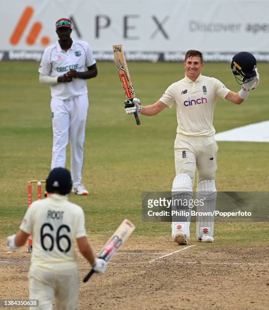 Zak Crawley of England reaches his century and smiles towards Joe Root during the fourth day of the first Test against West Indies at Sir Vivian...