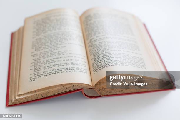 open old red hardcover book on a white table - libro rilegato foto e immagini stock