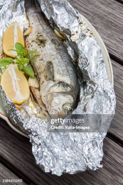 fresh fish prepared with herbs and lemon in foil - omega 3 fish stock pictures, royalty-free photos & images
