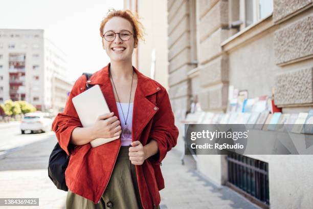 porträt eines rothaarigen mädchens, das aufs college geht und ein digitales tablet trägt - student ipad stock-fotos und bilder