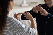Couple communicating at home using sign language, closeup