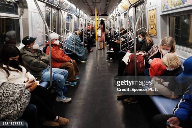 People ride on a MTA subway F train on March 11, 2022 in New York City. On the second anniversary of the pandemic, New York City, which saw some of...