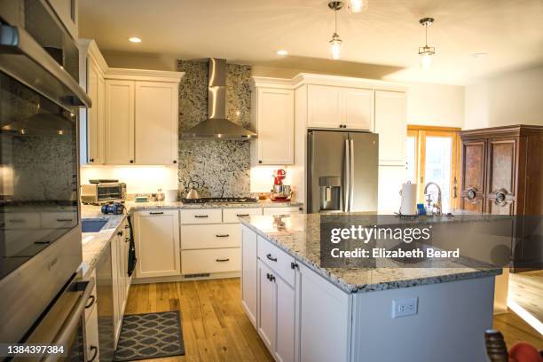 newly renovated kitchen with white cabinets and granite countertops - kitchen island ストックフォトと画像