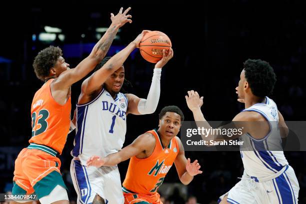 Trevor Keels passes Jeremy Roach of the Duke Blue Devils as Kameron McGusty and Charlie Moore of the Miami Hurricanes defend during the second half...