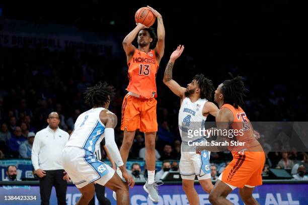 Darius Maddox of the Virginia Tech Hokies shoots the ball as Leaky Black and R.J. Davis of the North Carolina Tar Heels defend during the first half...