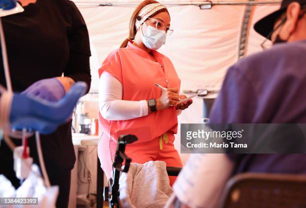 Registered nurse Kaila Cunningham works in the triage tent at Providence St. Mary Medical Center on March 11, 2022 in Apple Valley, California. The...