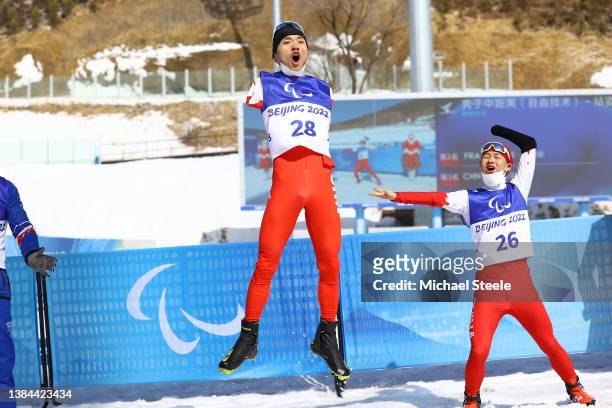 Chenyang Wang of Team China reacts after winning the gold medal as Jiayun Cai of Team China looks on following the Men's Middle Distance Free...