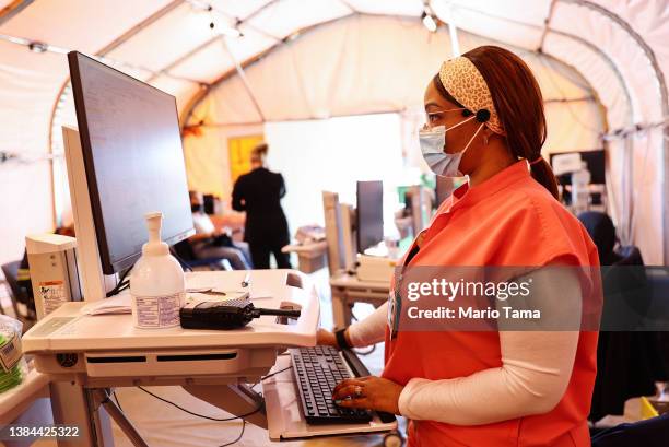 Registered nurse Kaila Cunningham works in the triage tent at Providence St. Mary Medical Center on March 11, 2022 in Apple Valley, California. The...