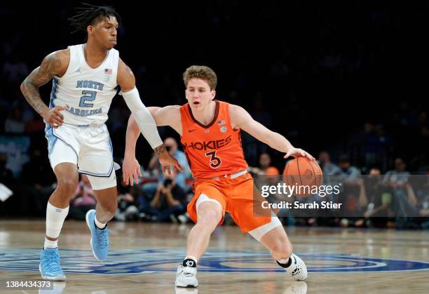 Sean Pedulla of the Virginia Tech Hokies dribbles as Caleb Love of the North Carolina Tar Heels defends during the first half in the 2022 Men's ACC...