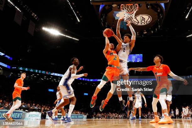 Isaiah Wong of the Miami Hurricanes goes to the basket as Paolo Banchero of the Duke Blue Devils defends during the second half in the 2022 Men's ACC...