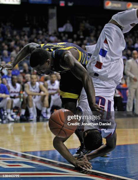 Moses Morgan of the DePaul Blue Demons falls over Darius Johnson-Odom of the Marquette Golden Eagles at Allstate Arena on February 6, 2012 in...