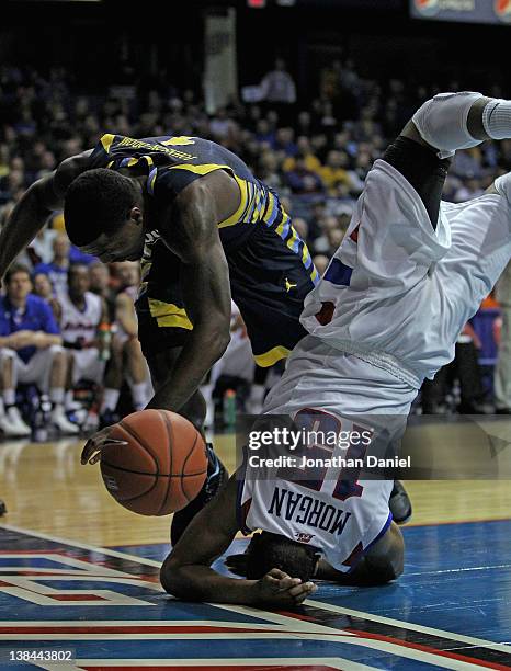 Moses Morgan of the DePaul Blue Demons lands on his head after flipping over Darius Johnson-Odom of the Marquette Golden Eagles at Allstate Arena on...