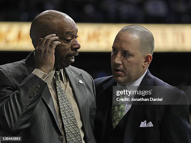 Head coach Buzz Williams of the Marquette Golden Eagles confers with head coach Oliver Purnell of the DePaul Blue Demons after Moses Morgan of the...