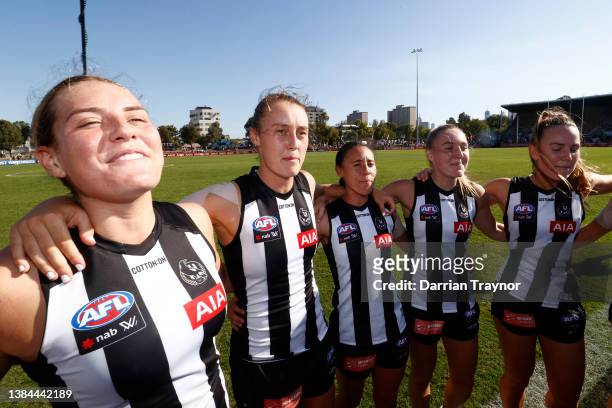 Collingwood players sing the team song after the round 10 AFLW match between the Collingwood Magpies and the Richmond Tigers at Victoria Park on...
