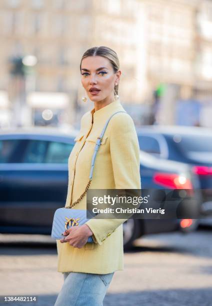 Guest is seen wearing yellow jacket, blue pants, bag, heels outside Chanel during Paris Fashion Week - Womenswear F/W 2022-2023 on March 08, 2022 in...