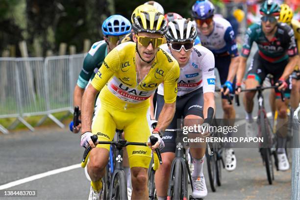 Team Emirates' British rider Adam Yates wearing the overall leader's yellow jersey cycles ahead of UAE Team Emirates' Slovenian rider Tadej Pogacar...