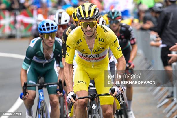 Team Emirates' British rider Adam Yates wearing the overall leader's yellow jersey cycles ahead of his brother Team Jayco Alula's British rider Simon...