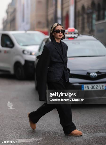 Alexandra Guerain wearing black shades, gold earrings, a black blazer, a black shirt, black wide pants and UGG chestnut Classic Mini II Boot on March...