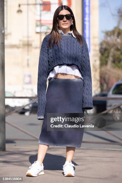 Alessandra Airo wearing a grey cropped sweater, grey midi skirt and white Miu Miu sneakers, is seen outside Miu Miu, during Paris Fashion Week -...