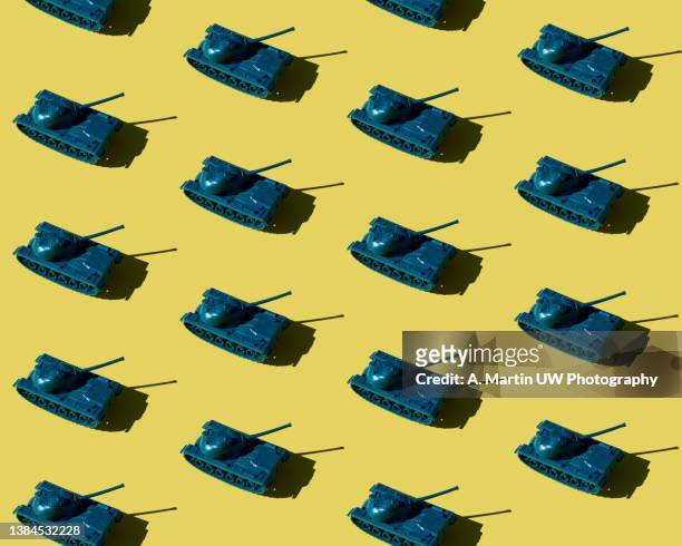 plastic toy tanks pattern isolated on yellow background. - space weapon stock pictures, royalty-free photos & images