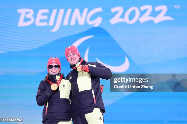 Gold medalist Linn Kazmaier of Team Germany and their guide Florian Baumann celebrate on the podium during the medal ceremony for the for the Women's...
