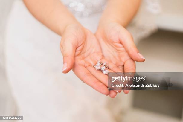 the bride holds in her hands and shows her earrings with precious stones, close-up. morning of the bride. the wedding day. - earrings stock pictures, royalty-free photos & images